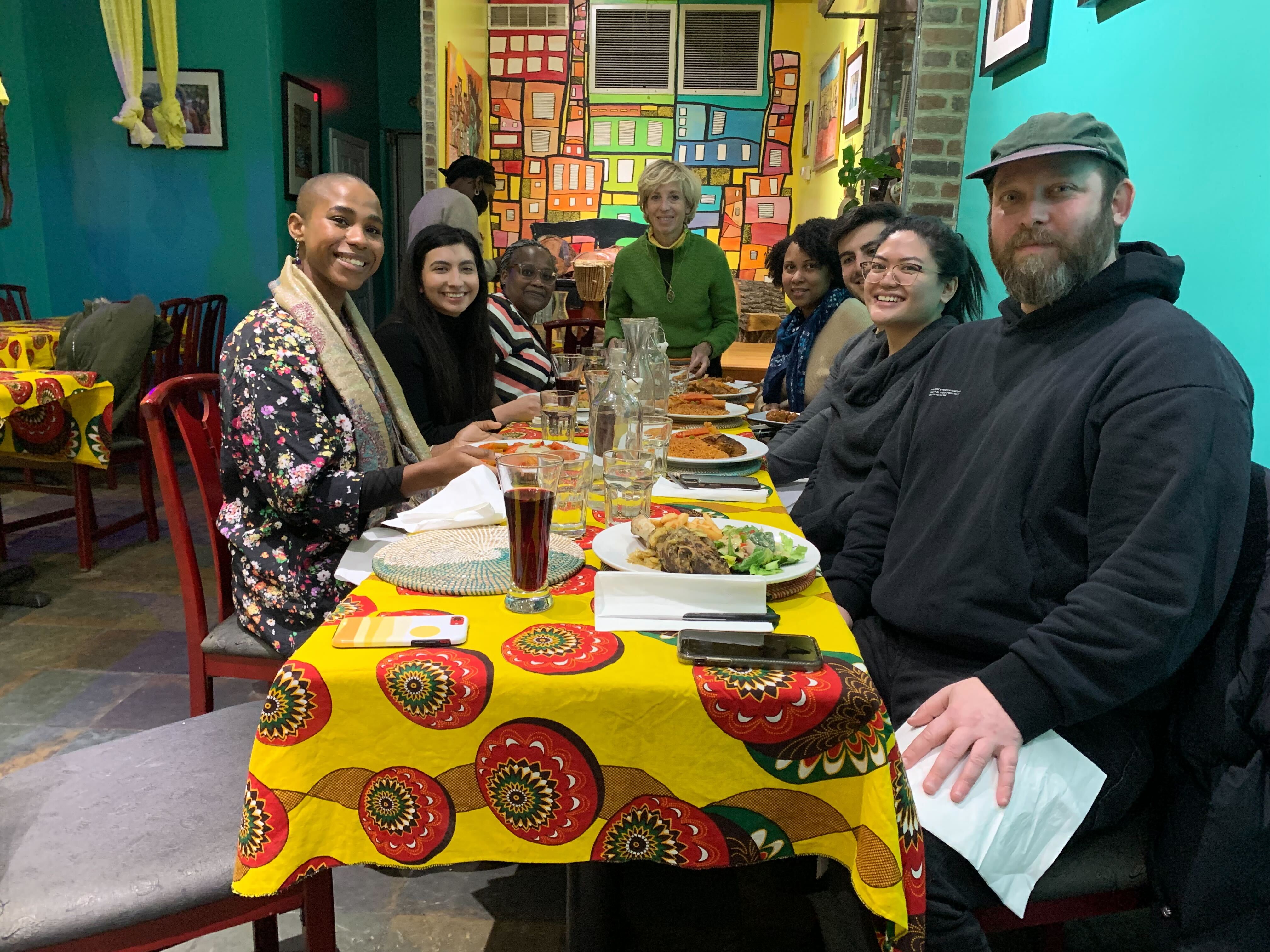 US staff enjoying dinner at a Senegalese restaurant after a team museum outing.